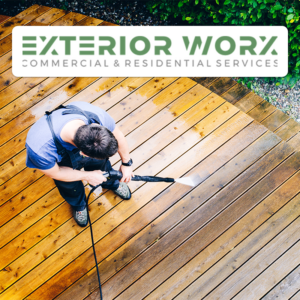 Worker pressure washes wooden deck from above, spraying boards clean; Exterior Worx logo overlay in corner