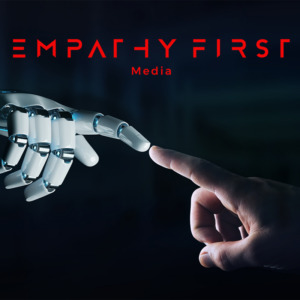 Robotic hand reaches to touch a human fingertip on dark background, with red Empathy First Media logo above