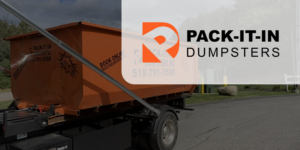 Orange PACK-IT-IN Dumpsters trailer parked on roadside, logo overlay on panel, waste removal service