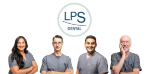 Four smiling dentists in gray scrubs stand under the LPS Dental logo on white background, friendly team