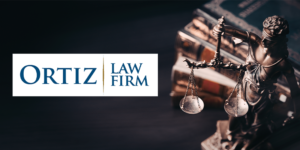 Lady Justice statue with scales beside stacked law books, Ortiz Law Firm logo on left against dark background