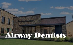 Exterior view of a modern dental clinic building with large windows, featuring bold text that reads Airway Dentists